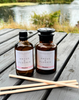 Two bottles of Angus & Florrie products on a wooden surface with a natural background