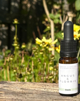 Bottle of Angus & Florrie Oasis essential oil with a dropper on a wooden surface with a natural background.