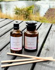 Two bottles of Angus & Florrie products on a wooden surface with a natural background