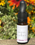 Bottle of Angus & Florrie Serenity oil with flowers in the background