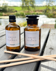 Two bottles of Angus & Florrie Tranquil product on a wooden table with a scenic background.