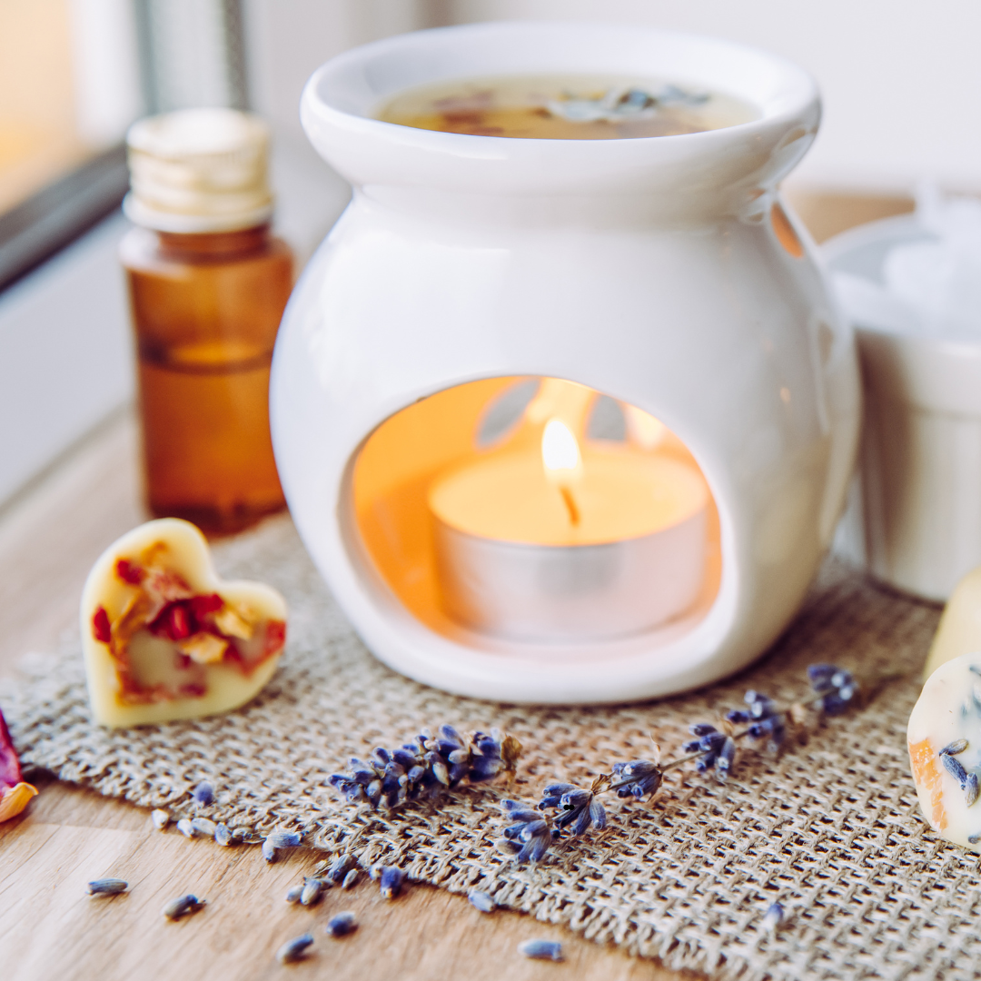 Wax melter on a rattern cloth with essential oils in the back ground