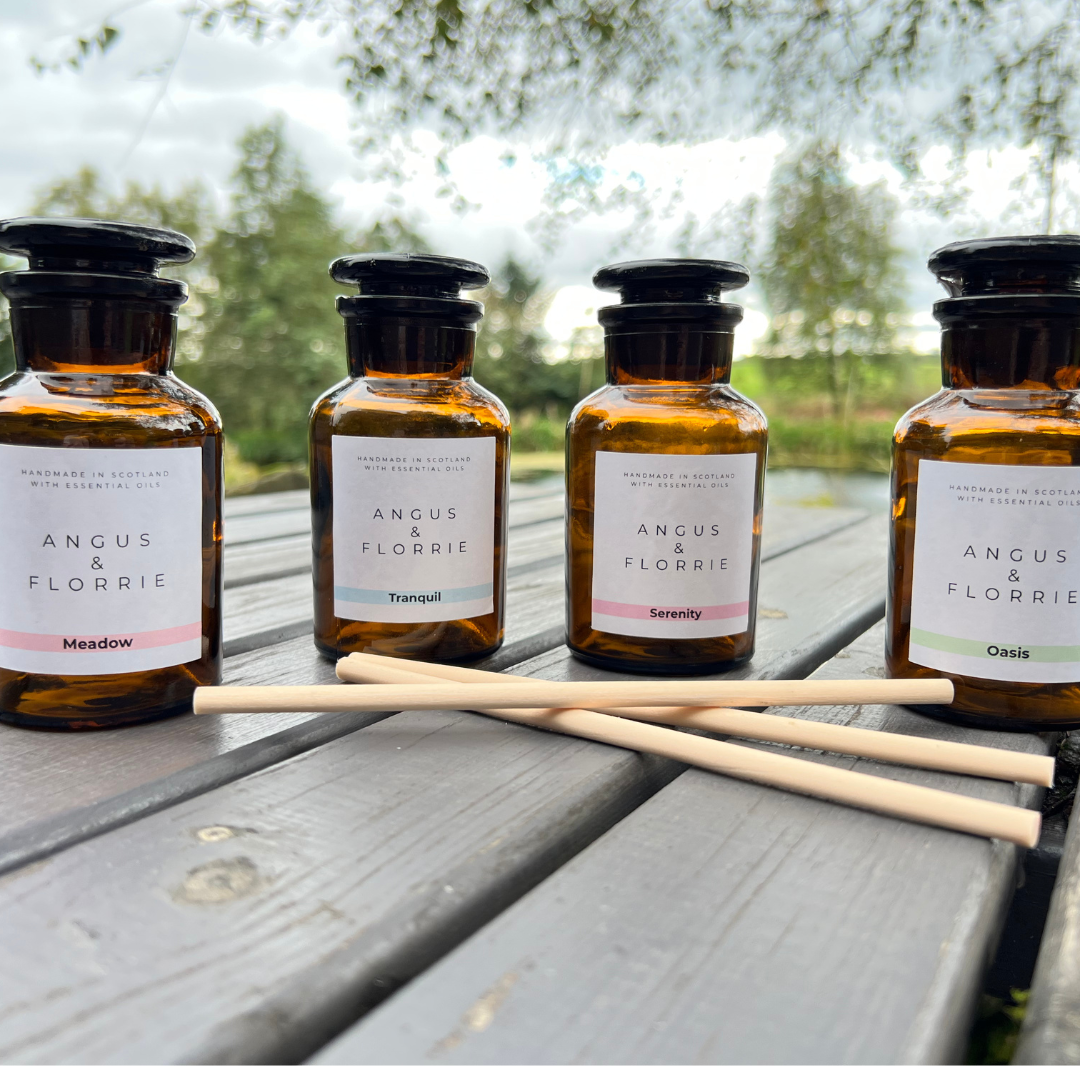 Four bottles of Angus &amp; Florrie products on a wooden surface with a natural background.