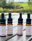Four bottles of Angus & Florrie products on a wooden surface with a natural background.