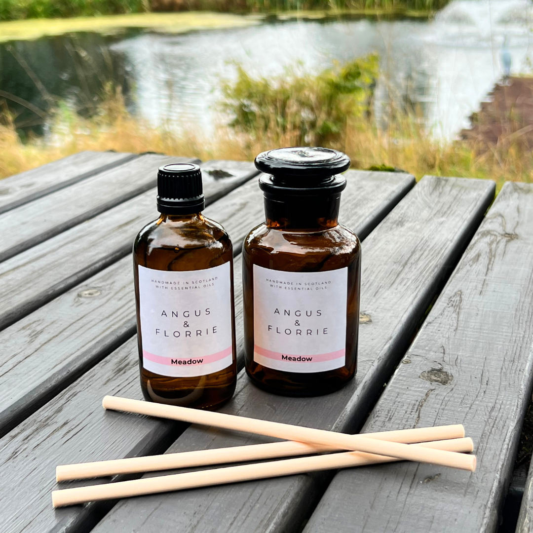 Two bottles of Angus & Florrie products on a wooden surface with a natural background
