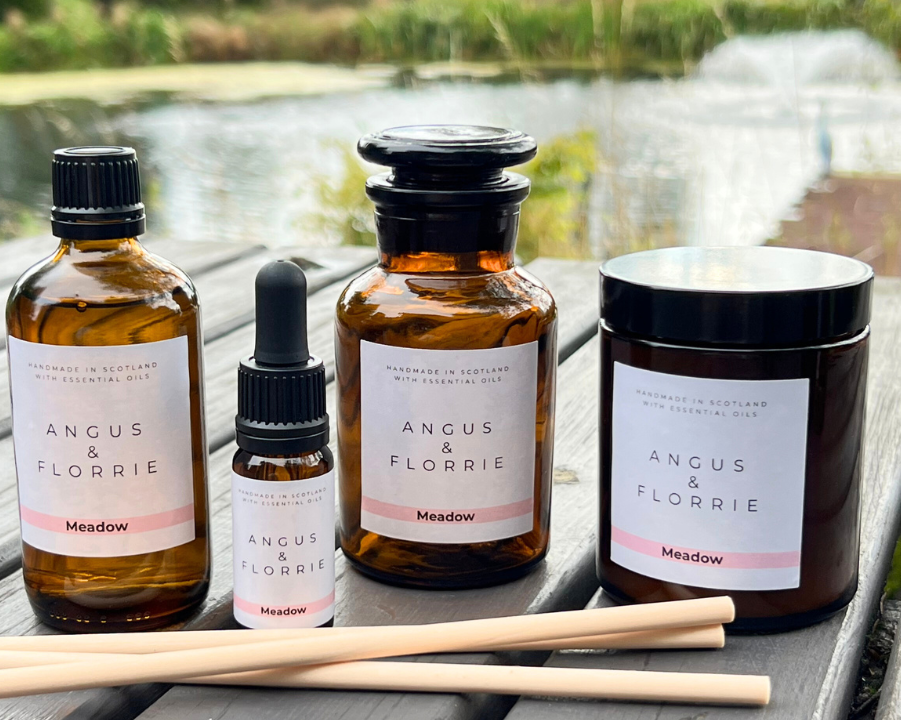 Collection of Angus & Florrie products on a wooden table with a scenic background