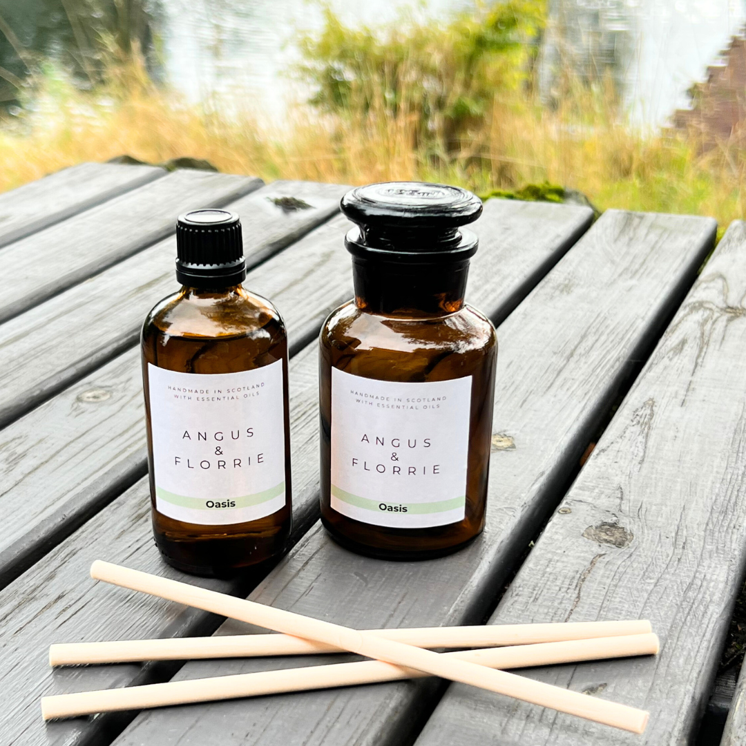 Two bottles of Angus & Florrie product on a wooden surface with a natural background