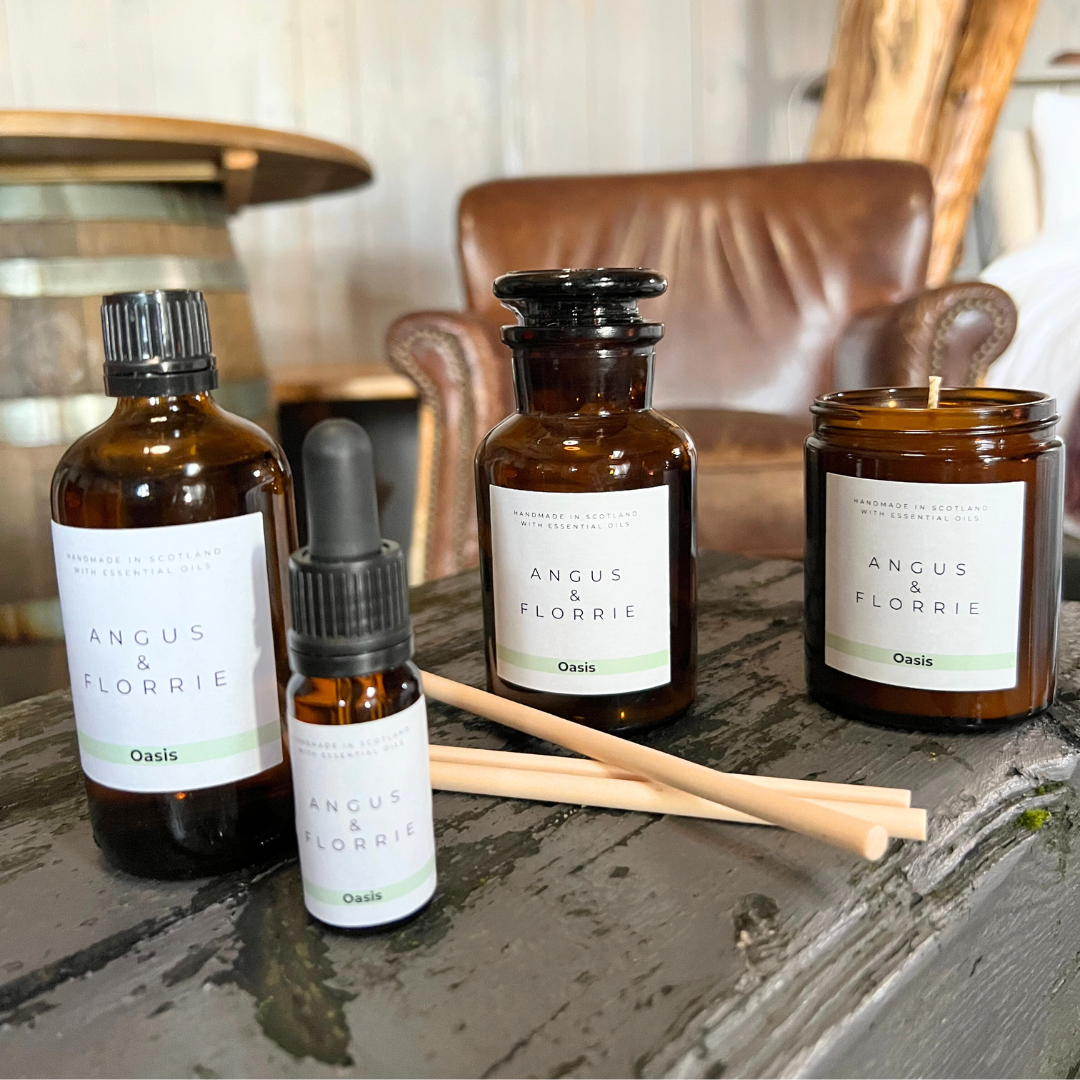 Collection of Angus & Florrie product bottles and a candle on a wooden surface.
