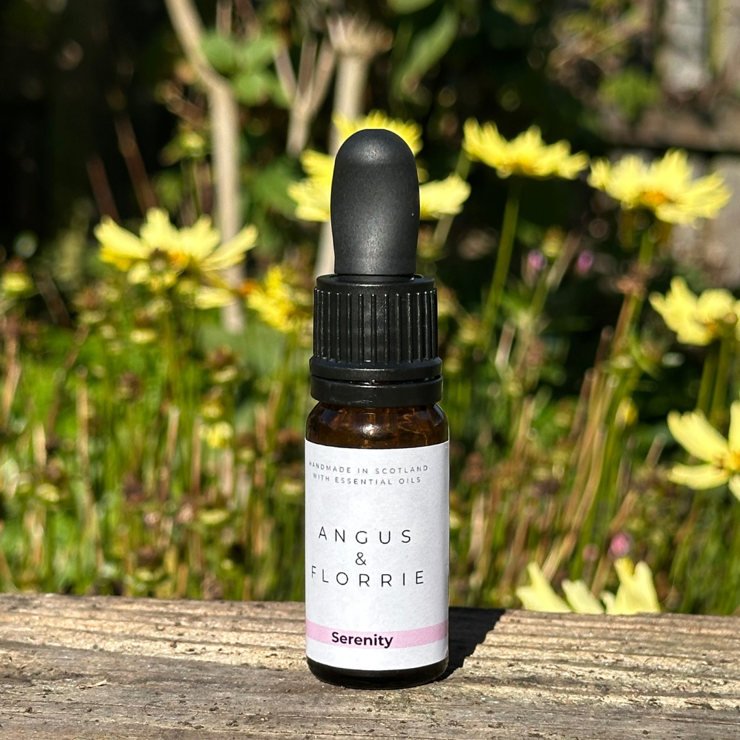 Bottle of Angus & Florrie essential oil with a garden background
