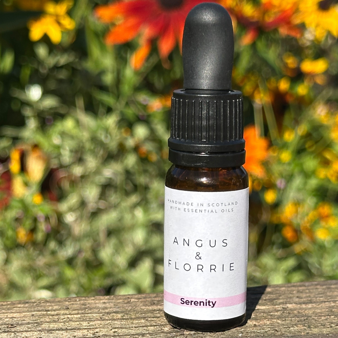 Bottle of Angus & Florrie Serenity oil with flowers in the background