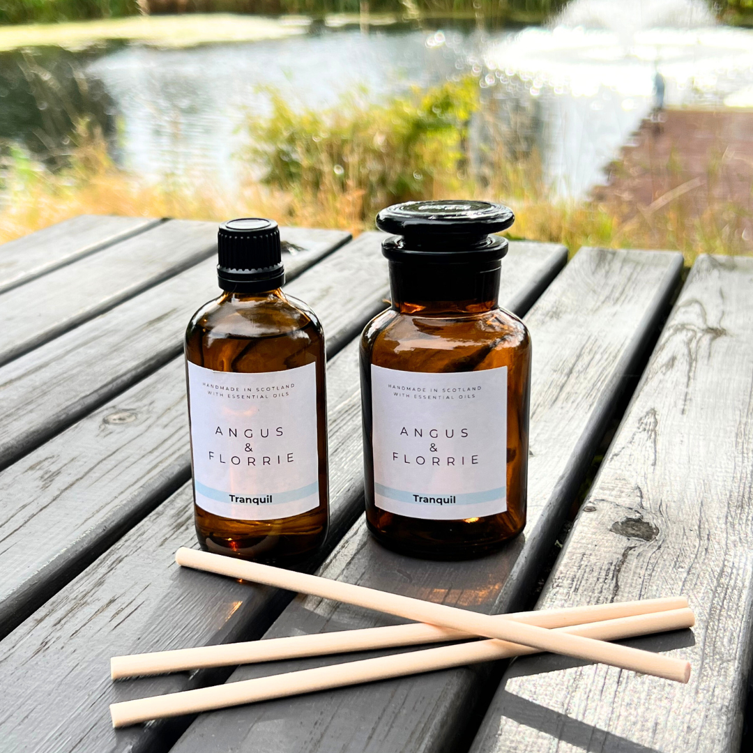 Two bottles of Angus & Florrie products on a wooden surface with a natural background